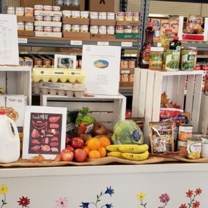 Community Sharing Outreach's pantry featuring a table with toiletries, dairy products, fruit, and canned goods